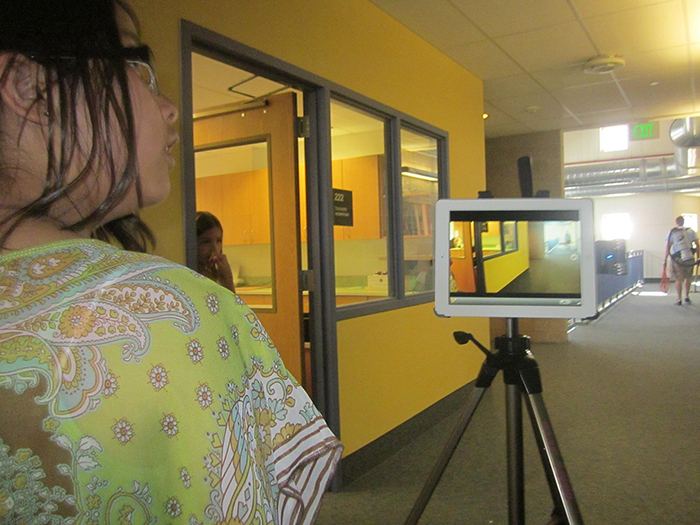 A student in the school's halls filming with an iPad