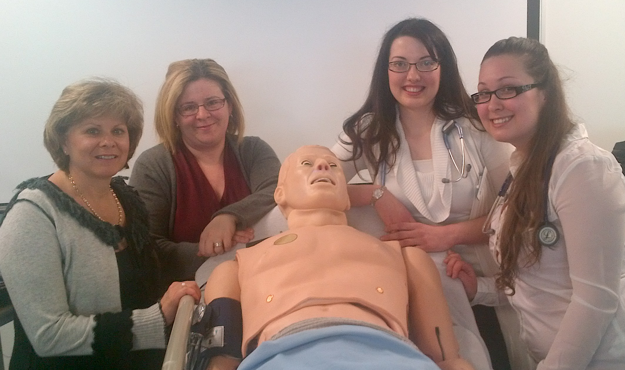 Gloria et Lyne avec des étudiantes et le mannequin Hal, près la simulation d’une embolie pulmonaire en laboratoire